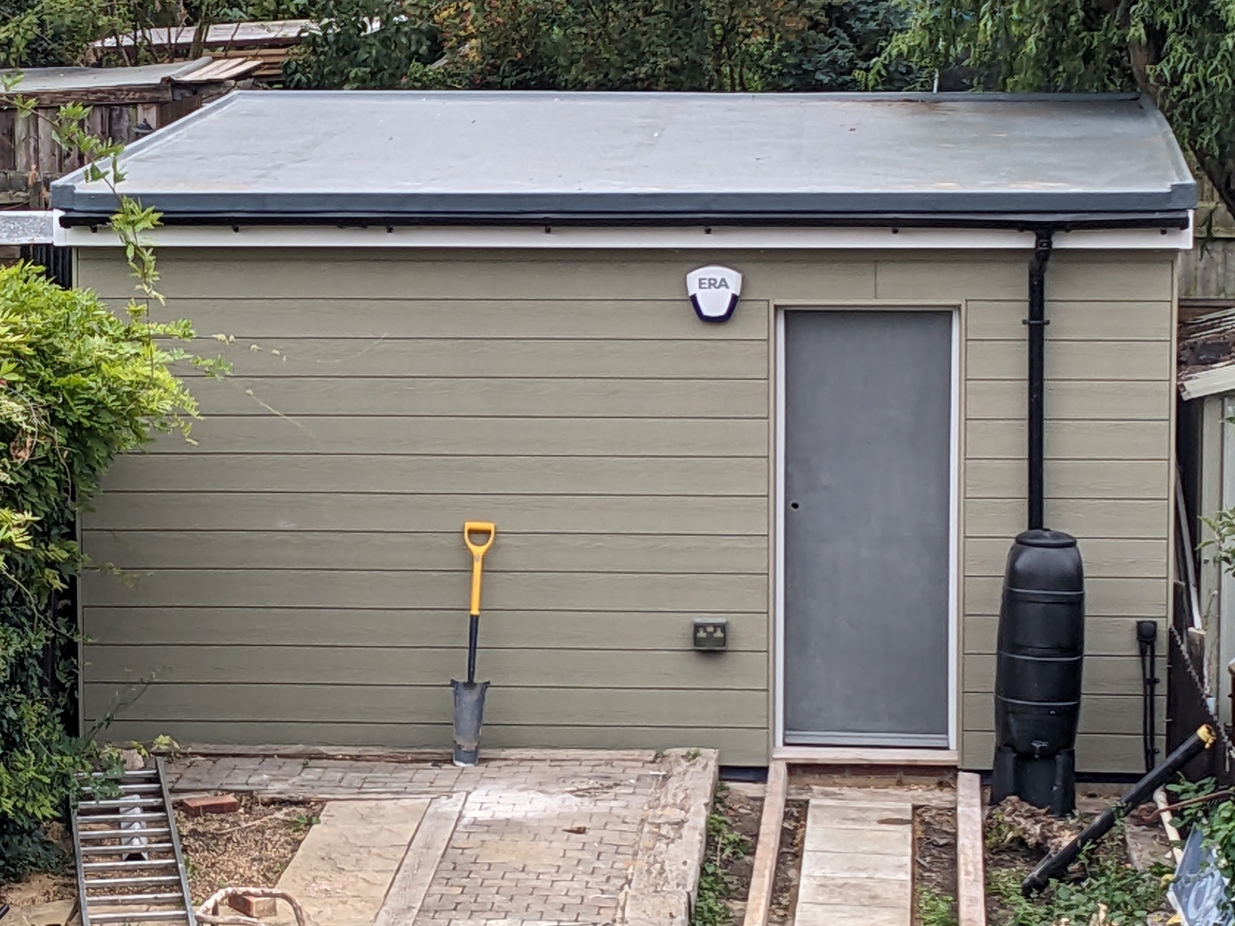 Exterior view showing the roof with gutter and rain barrel.